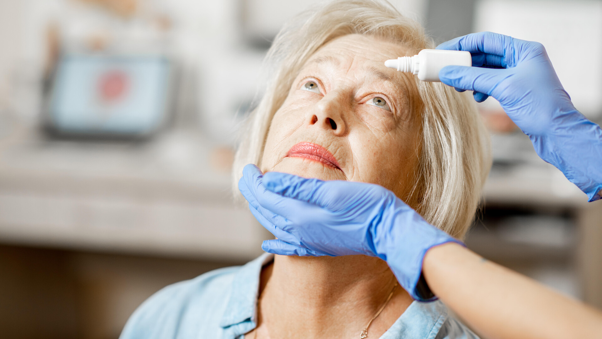 Bild på kvinna som får ögondroppar av sjuksköterska